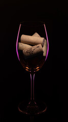 a glass of wine with corks in it