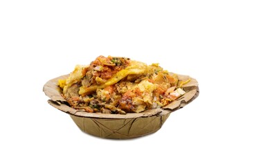 Closeup of Papri Chat or Papri Chaat Garnished with Chili, Onion Cuts, Tomato Sauce and Spices in a Dry Leaves Disposable Bowl Isolated on White Background with Copy Space, Indian Street Food