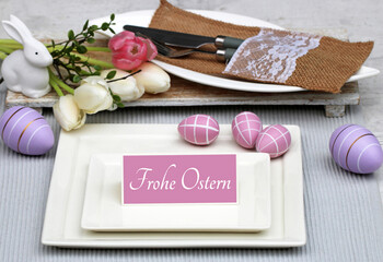 Tischdeko zu Ostern: Teller, Besteck und Osterdeko mit dem Text Frohe Ostern auf einer Tischkarte.
