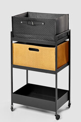 Two woven storage containers, in black leather and yellow suede on office cart © nazarovsergey