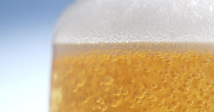 Super slow motion close up of fresh cold bio organic brewed beer in cool transparent glass with white bubbles foamy froth is going at 1000 fps.