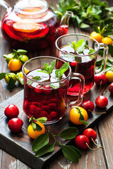 Hot   citrus and berries  tea,  drink in  glass cups and  teapot  with fresh mint  leaves