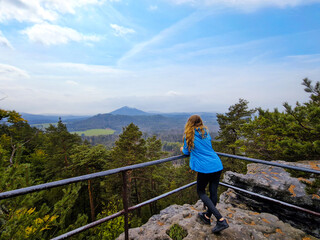 Fototapeta na wymiar Girl admires the mountain view during a break from climbing, hiking trip