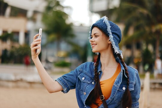 Stylish Woman Taking Selfie with Smartphone Against Urban Autumn Background