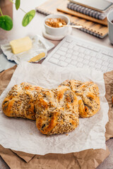 Breakfast at office workplace, fresh bread rolls with butter and cup of tea