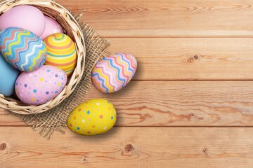 Fototapeta na wymiar Plate of colored Easter eggs on desk
