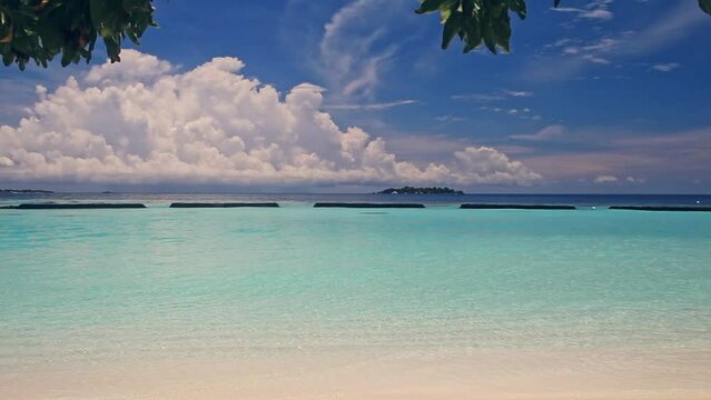 Daylight Serenity: A Summer Vacation at a Maldivian Beach with Turquoise Sea, White Sandy Shore, and Gentle Waves Lapping