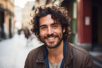 Portrait of a handsome young man with curly hair smiling at the camera