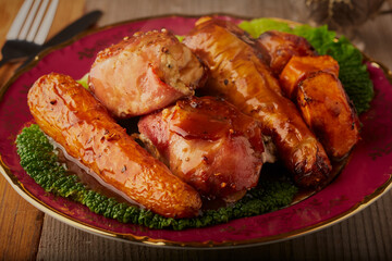 Chicken thighs wrapped in bacon with roasted vegetables and a rich gravy.
