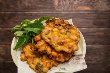 Corn Fritters with Corn. Healthy and Diet Food . Crispy fried corn ball in a white plate on wooden table, Vegetarian food, Thai food, snacks Thai style. Zucchini fritters or vegetarian zucchini pancak