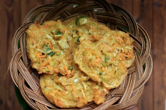 Corn Fritters with Corn. Healthy and Diet Food . Crispy fried corn ball in a white plate on wooden table, Vegetarian food, Thai food, snacks Thai style. Zucchini fritters or vegetarian zucchini pancak