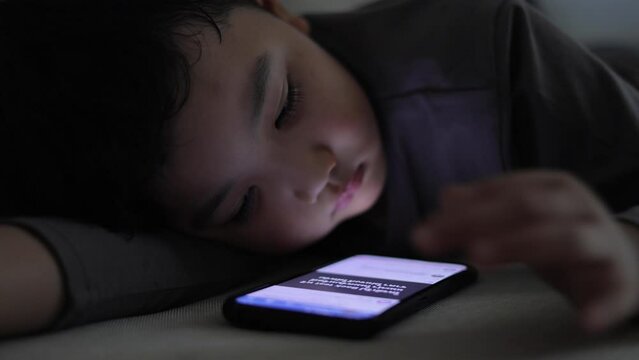 boy lying on the sofa using a phone