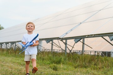 A little boy is having fun near the solar panels. The concept of solar energy.