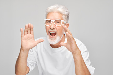 Portrait of senior man in white shouting loudly with hands, news, palms folded like megaphone...