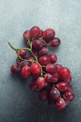 Luscious Red Grapes Bunch on a Coarse Textured Grey Surface
