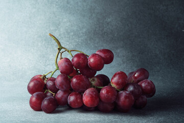 Fresh Red Grapes Bunch on Textured Grey Background