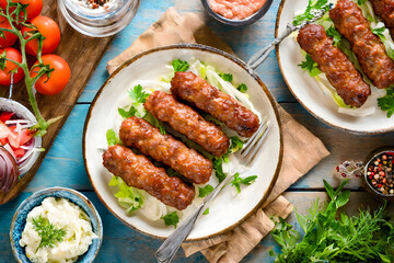A traditional Balkan dish, Cevapi, served with fresh vegetables and flatbread
