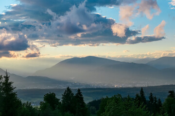 Obraz premium Scenic sunset view of mountain range Bleiberg Erzberg seen from Altfinkenstein, Baumgartnerhoehe, Carinthia, Austria. Tranquility on hiking trail. Overlooking Villach area surrounded by Austrian Alps