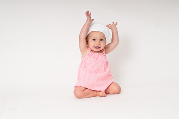 Little girl sitting on the floor with arms up in the air