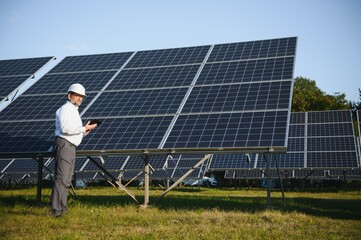 Senior engineer working on solar panel farm. The concept of green energy