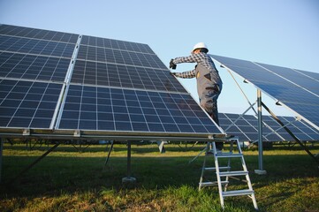 An Indian worker installs solar panels. The concept of renewable energy.