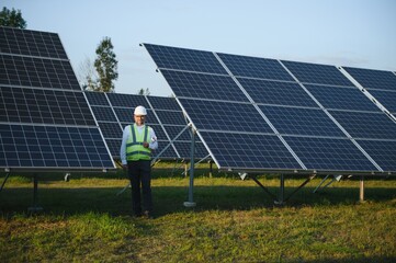 Industrial senior man engineer walking through solar panel field for examination