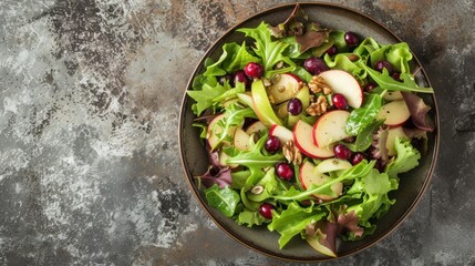  a close up of a plate of salad with apples and cranberries on a gray table with a grungy background and a spoon to the side of the salad.