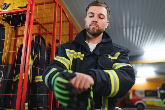 A firefighter puts on a fire uniform at the fire department