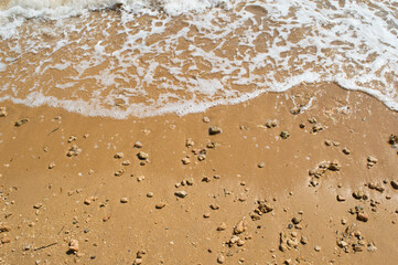 Sandy beach with pebbles and foam of the waves, Adriatic coast, Croatia