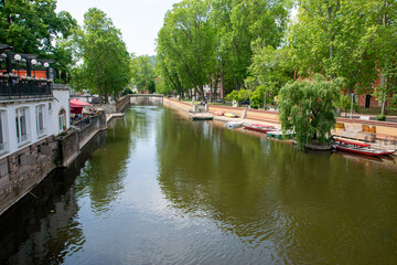 River embankment in Europe with houses, boats and trees.