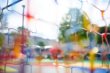 Bokeh-style background featuring an empty children's playground. This serene image captures the whimsical charm and potential for fun and adventure in a playground setting. Ideal for promoting outdoor
