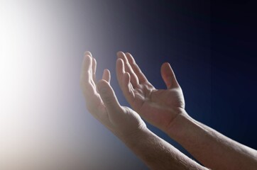 Pray hands open to the blue night sky