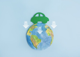 Green car, planet earth and symbol of hydrogen atom H2. Ecological transport. Reduction of carbon dioxide emissions. Ecology concept.