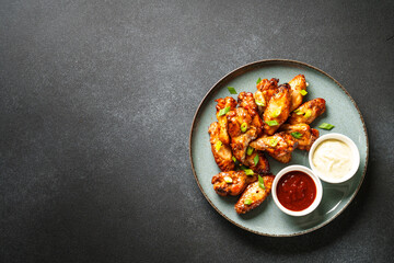 Chicken wings in bbq sauce grilled meat. Restaurant dish. Top view on black stone table.