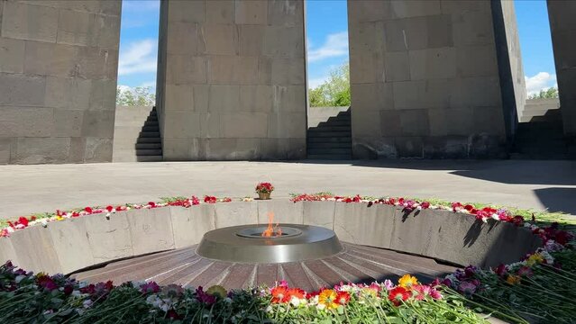 ARMENIA, YEREVAN - MAY 4, 2023: Flowers lie next to eternal fire in the memorial complex of the victims of the Armenian Genocide Memorial complex of 1915 Tsitsernakaberd
