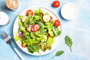 Green vegetable salad with fresh leaves on white plate. Healthy food, diet menu. Top view with space for text.