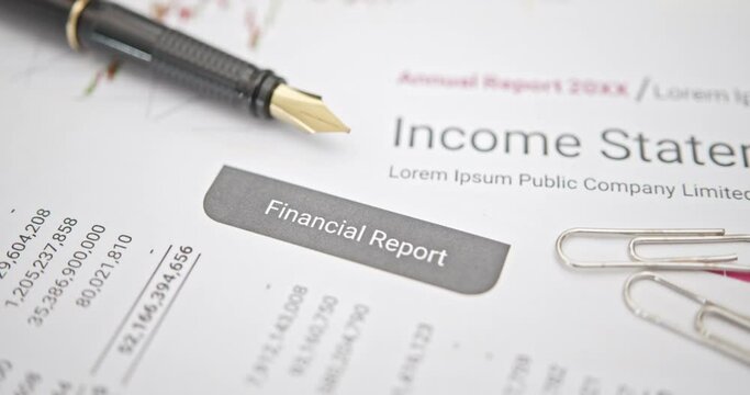 A pen atop quarterly corporate financial report, anticipating analysis by financial and investment expert prior to public disclosure. Illustrating financial analysis and investment insight concept.