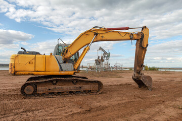 crawler excavator stands on background of an oil pump during the day, special equipment