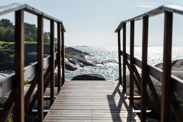 Wooden walkway on a rocky island by the sea during a sunny day