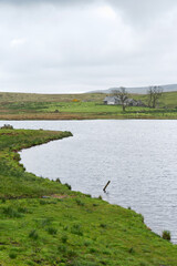 Haus mit Wolken am Loch Thom beim Greenock Cut im Clyde muirshiel regional park, bei Greenock, Inverclyde, Schottland