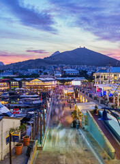 Victoria and Alfred, V and A waterfront lit up at dusk with signal hill in the background, Cape...