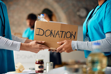 Close up of volunteers packing donation boxes at food bank.