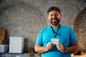 Portrait of happy volunteer with his ID card looking at camera.