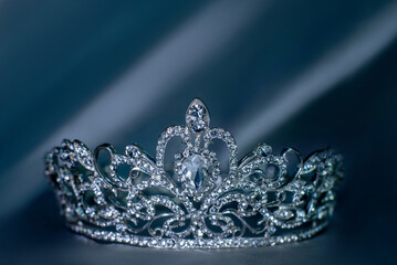 Luxury golden royal crown on smooth fabric fo queen and princess, Symbol of power and wealth, authority. Beauty contest