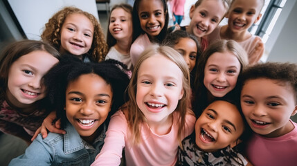 Fototapeta premium high angle view of smiling multicultural kids looking at camera in school corridor