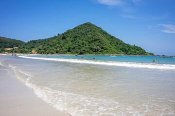 Sandy Beach Curving Around a Lush Green Mountainous Island