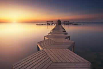 wooden walkway with geometric shapes goes into the Mar Menor, Murcia, at dawn