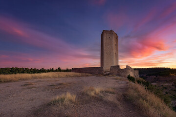 Alarcon weapons tower, Cuenca, at sunset with red clouds on blue sky