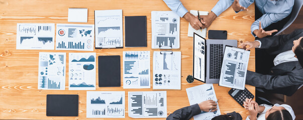 Panorama top view multiracial analyst team use BI dashboard display on laptop screen, analyzing financial data for strategic decision. Fintech analyzes marketing indicators. Concord