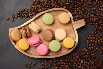 Multi-colored macarons on a background of coffee beans